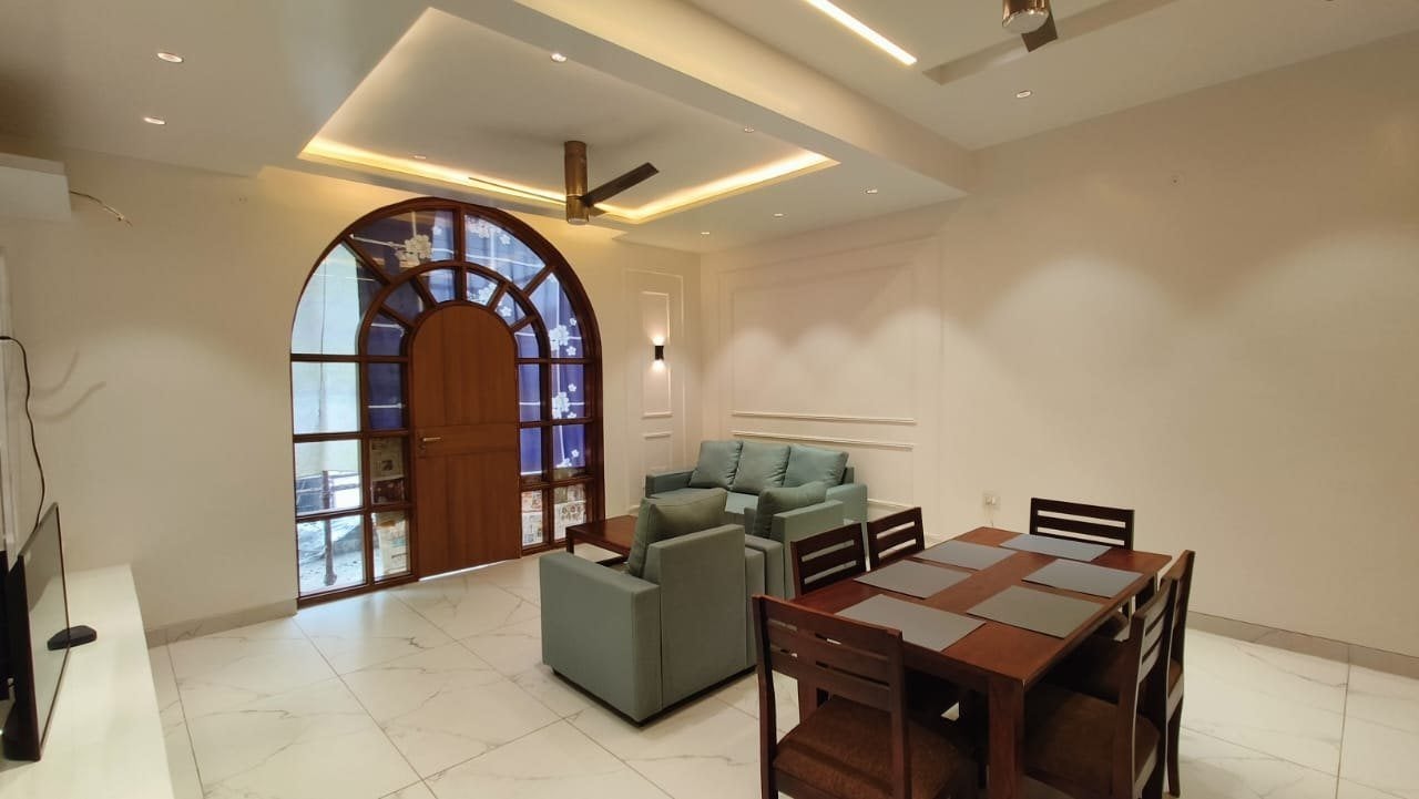 Residence at Sector 105, Noida — living room with the arched stained-glass window